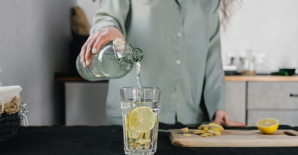 Woman pours water for lemon ginger infusion promoting health and hydration