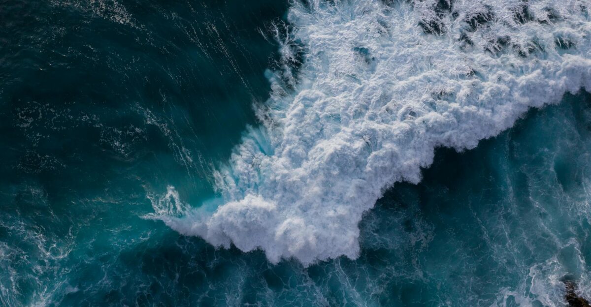 Aerial view of powerful ocean waves crashing against the rocks capturing the essence of nature s strength