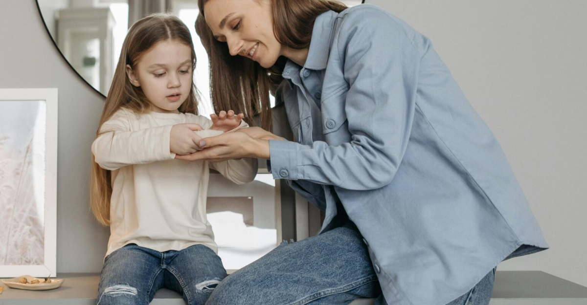 A loving mother shares a bonding moment with her daughter indoors, both in casual attire.