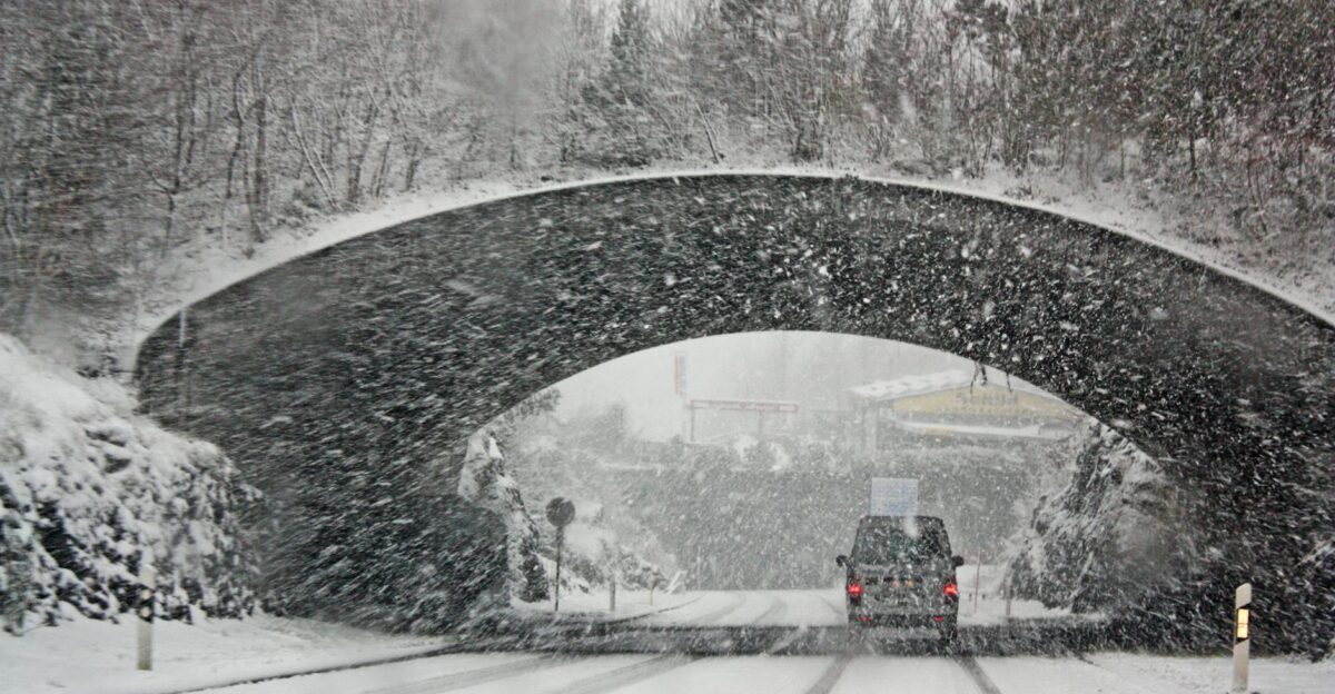 A winter storm covers a Swiss bridge in snow creating a beautiful yet hazardous landscape