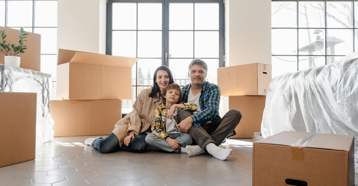 A joyful family sitting together amidst moving boxes marking a new beginning in their home