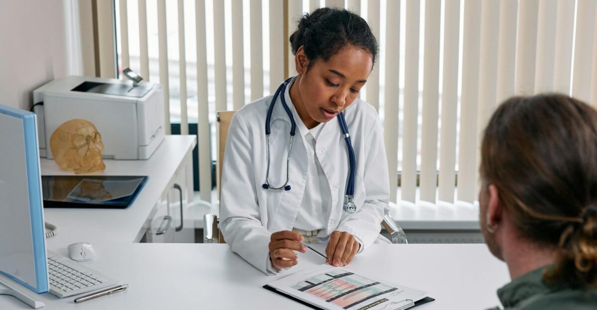 A doctor consulting with a patient in an office discussing a medical chart
