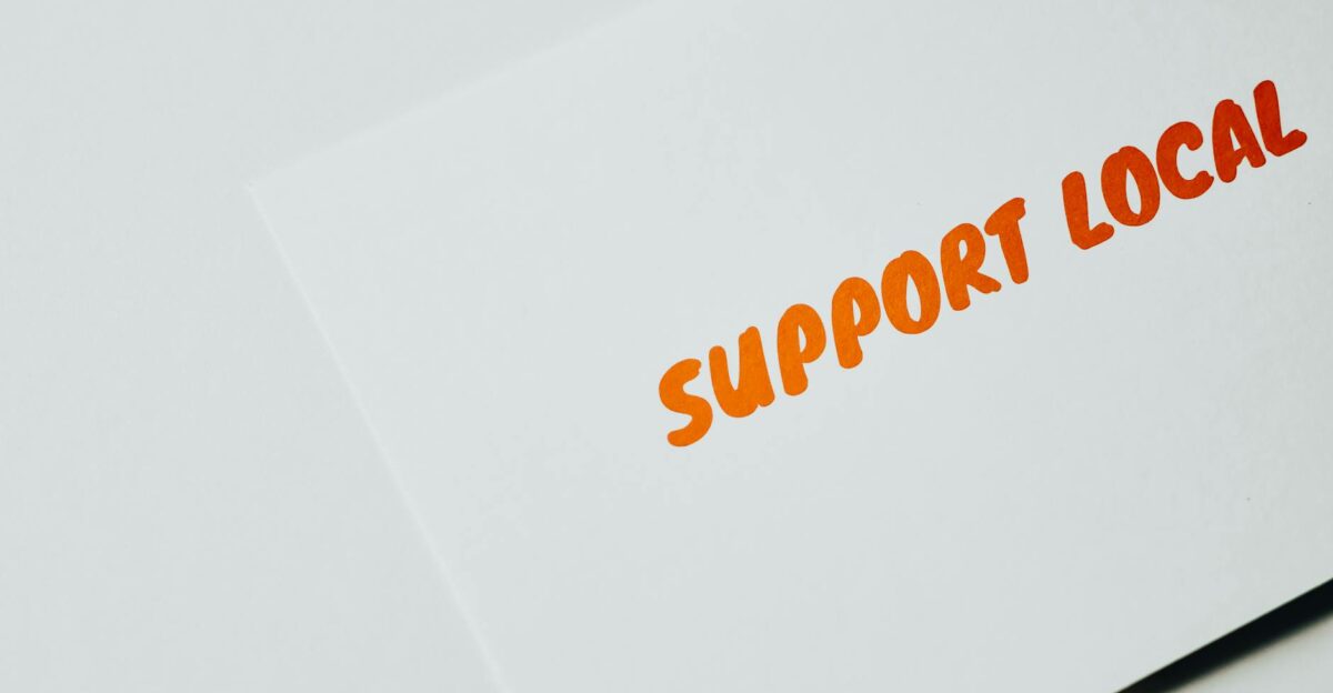 Close-up of Support Local message on white paper encouraging local support