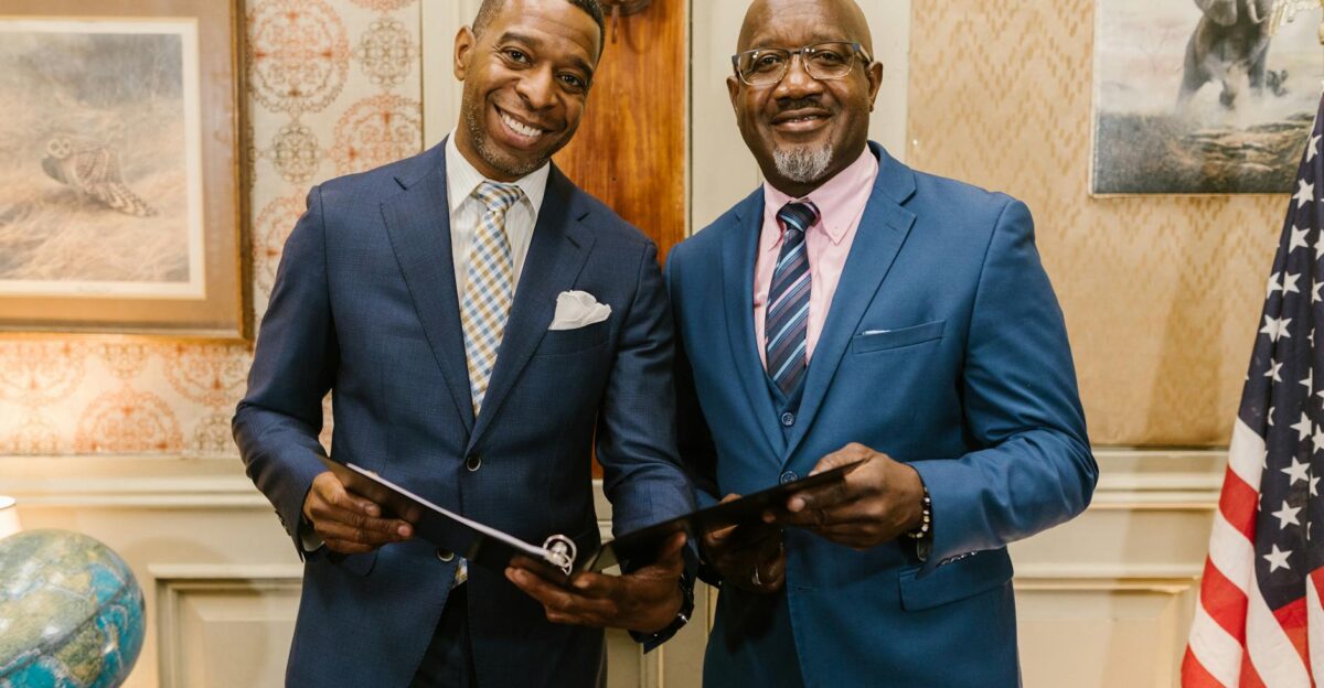 Two businessmen holding documents in an office symbolizing professionalism and collaboration