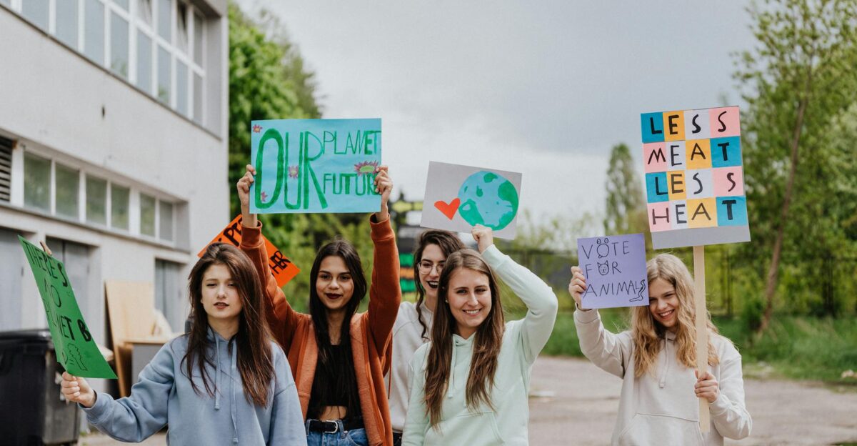 Group of young women holding signs during an outdoor environmental protest