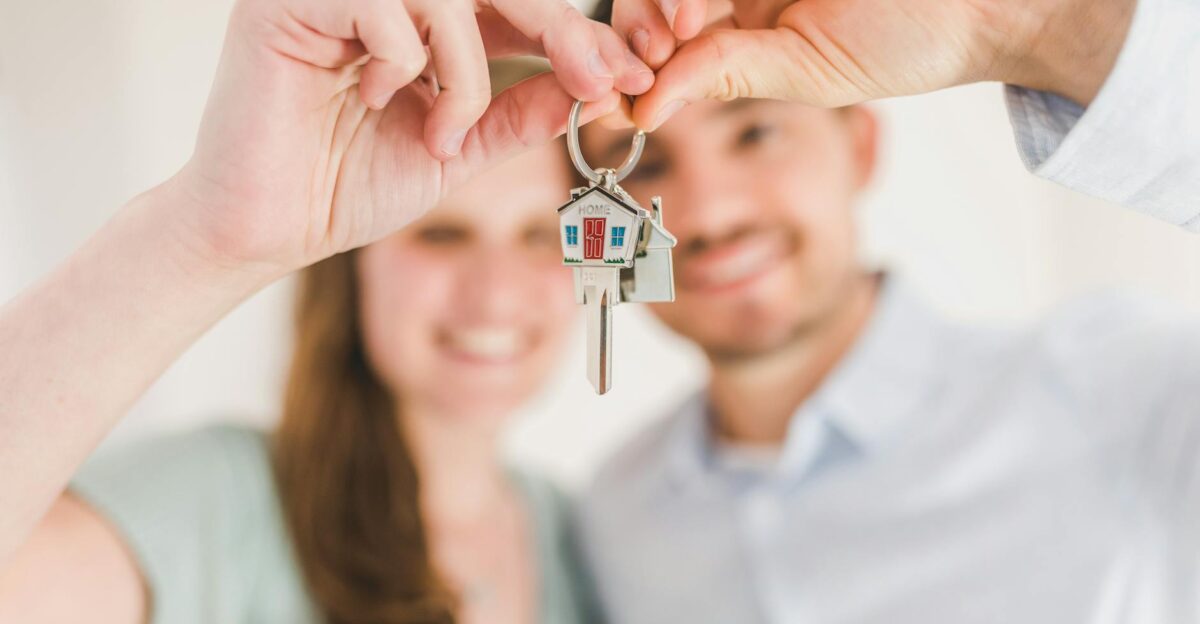 Young couple holding keys to their new home symbolizing a fresh start and investment in real estate