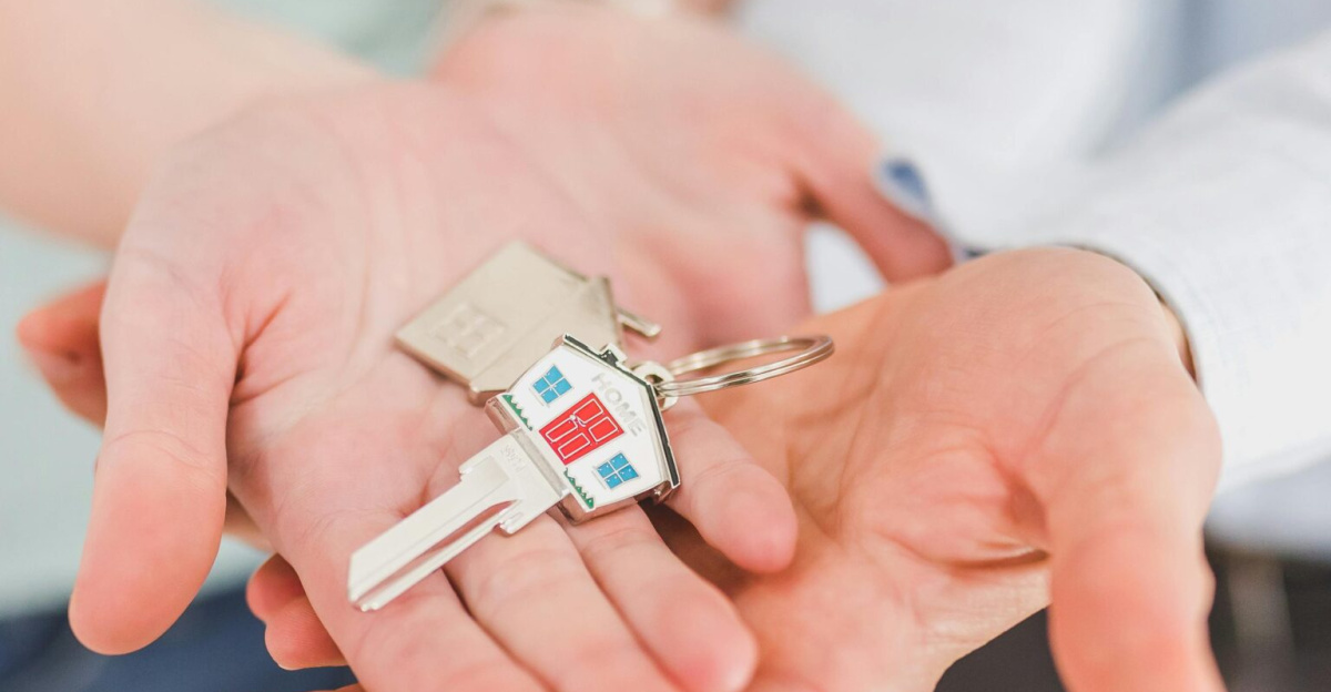 Close-up of a couple holding keys, symbolizing homeownership and investment.