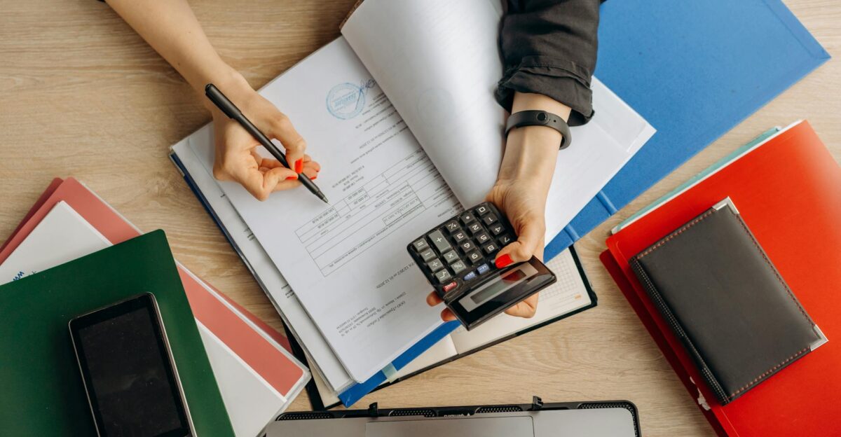 Accountant analyzing financial documents with a calculator on a desk highlighting business tasks