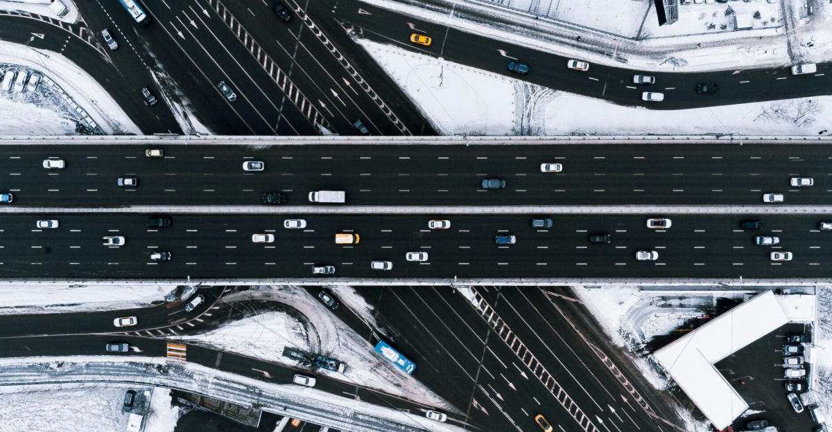 Aerial photograph of a multi-lane highway intersection surrounded by snow, captured in winter.