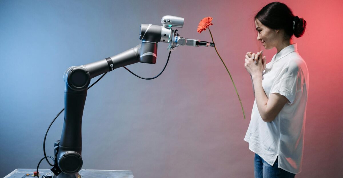 A robotic arm offers a flower to a woman in a display of technology and human connection