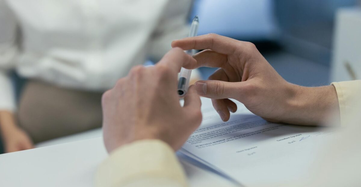 Close-up of hands holding a pen during a business meeting or contract signing