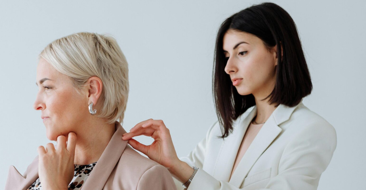 A fashion consultant adjusts a client's blazer in a modern studio setting, showcasing elegant style.