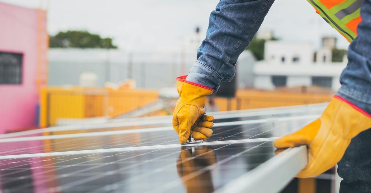 A solar technician performing maintenance on solar panels outdoors