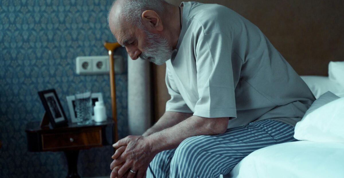 An elderly man sits thoughtfully on a bed conveying solitude and reflection