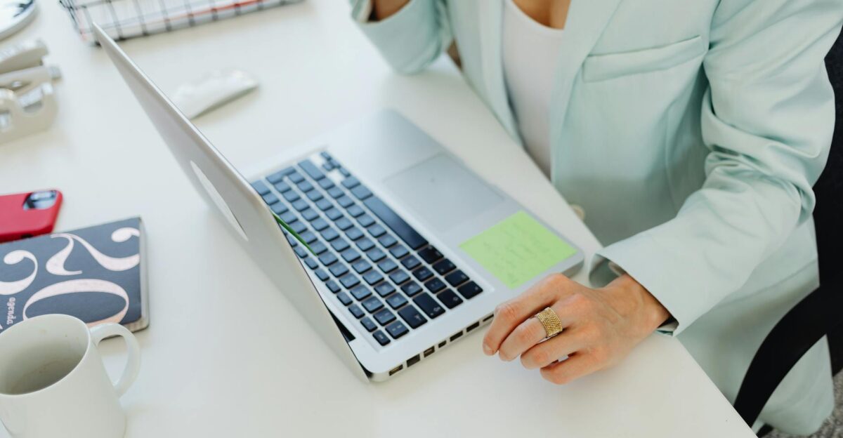 Businesswoman in office attire working on a laptop at a desk symbolizing modern professional life