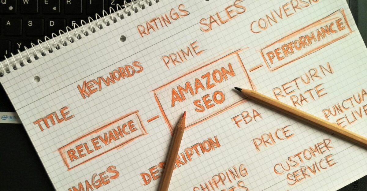 Notebook with handwritten Amazon SEO strategy topics highlighted on a keyboard