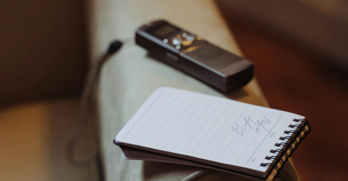 Cozy indoor setting with a notepad and recorder on a chair armrest.