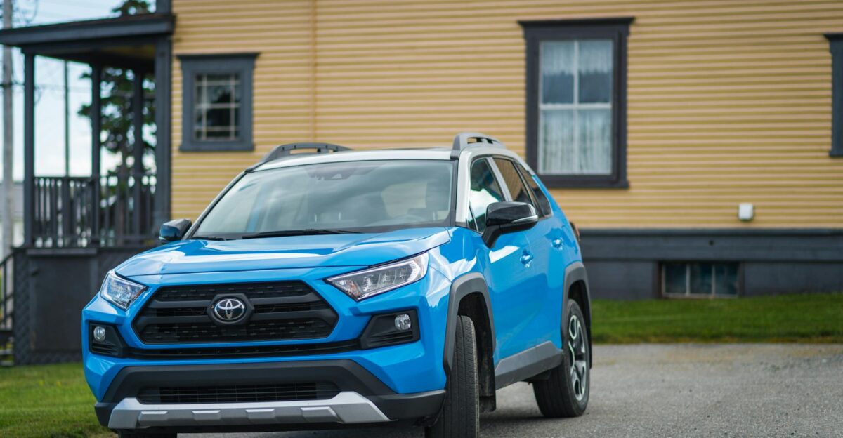 Blue Toyota RAV4 parked outside a house showcasing modern SUV design