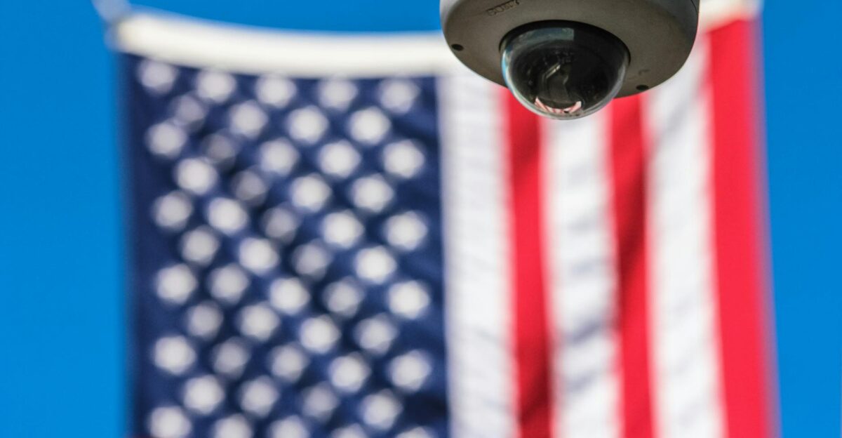 Surveillance camera focusing on security with American flag backdrop