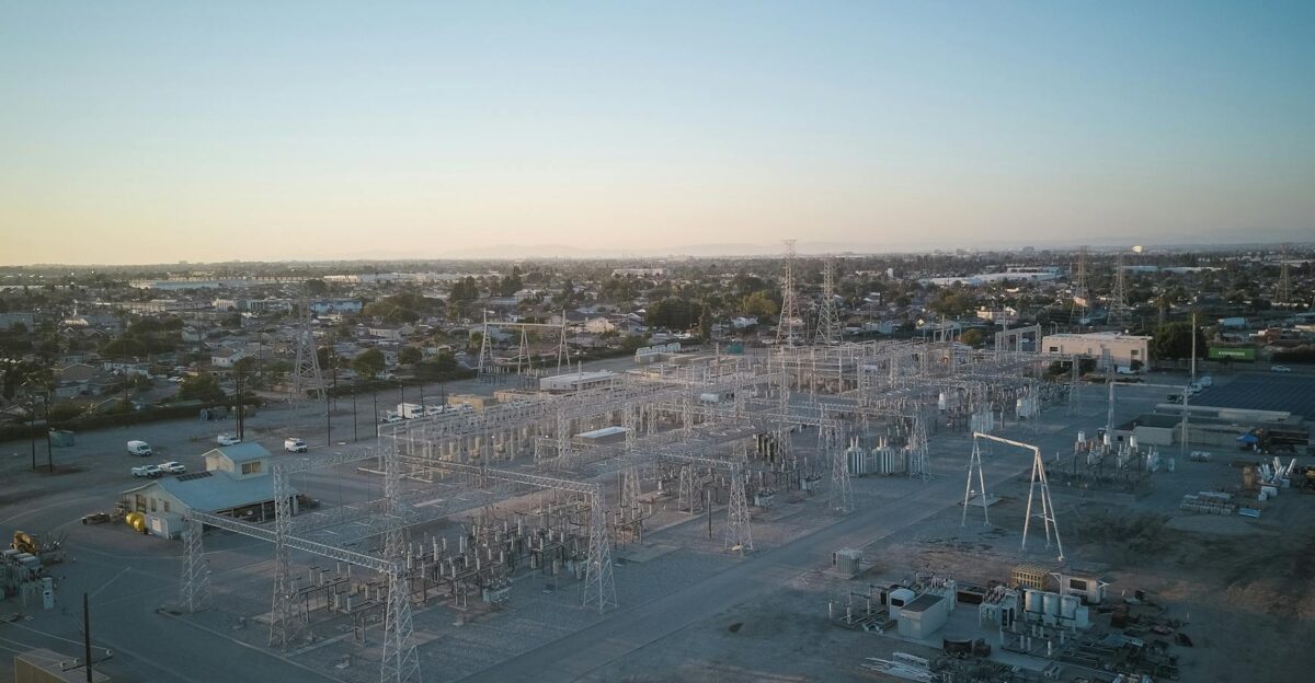 A wide view of a power station showcasing industrial infrastructure under a clear sky at sunset