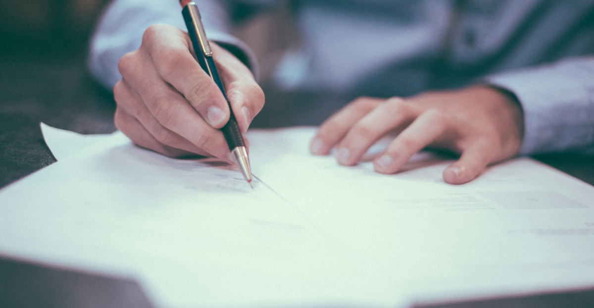 man writing on paper