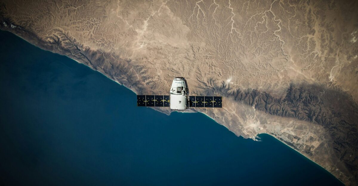 A space satellite hovering above the coastline