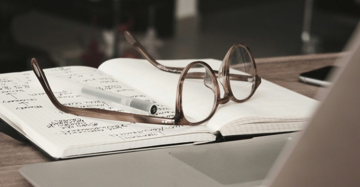 eyeglasses with gray frames on the top of notebook