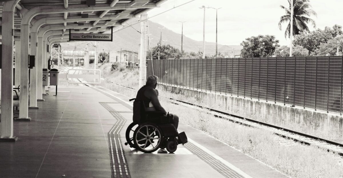 grayscale photo of person sitting on wheelchair