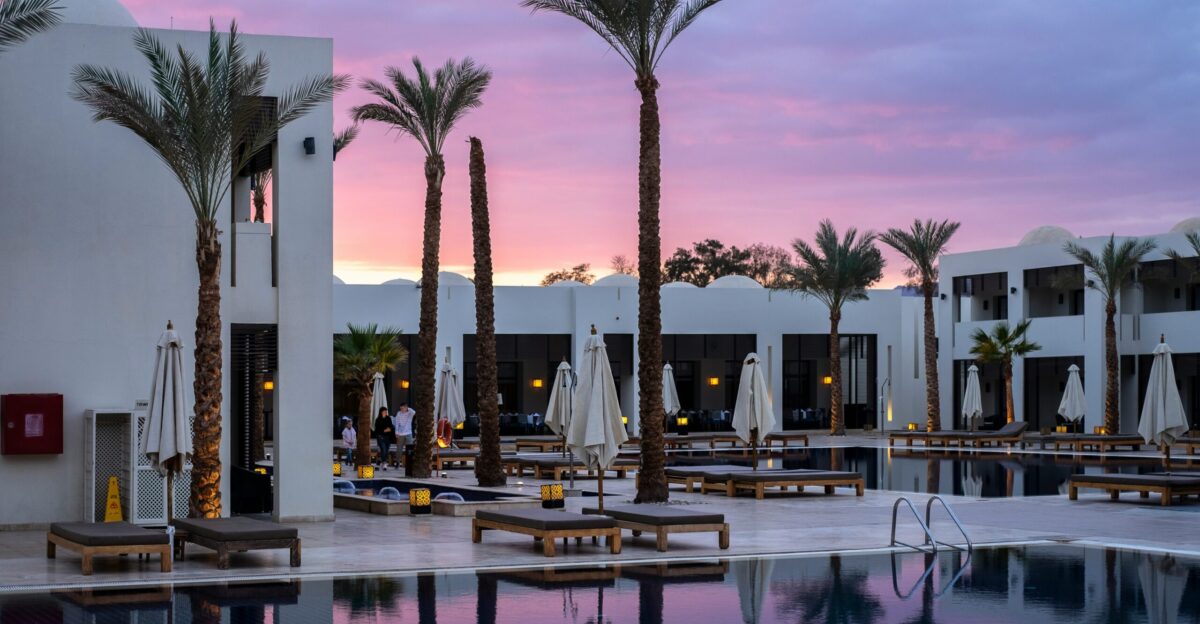a large swimming pool surrounded by palm trees