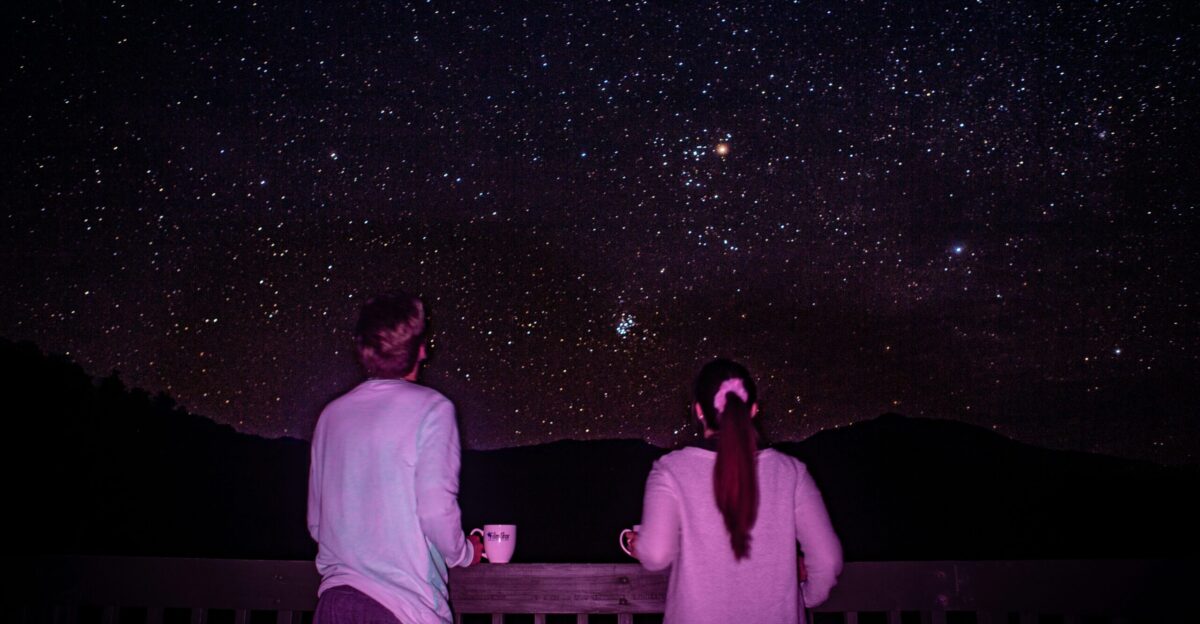 man and woman standing in front of galaxy