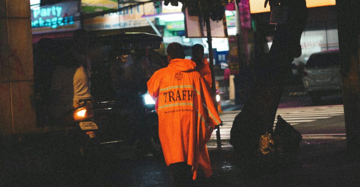 man in traffic reflectorized raincoat on road