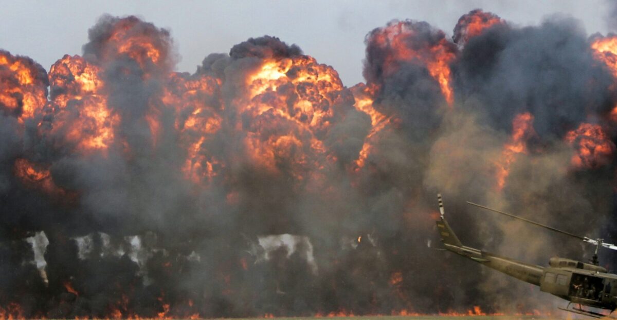 green helicopter near big fire