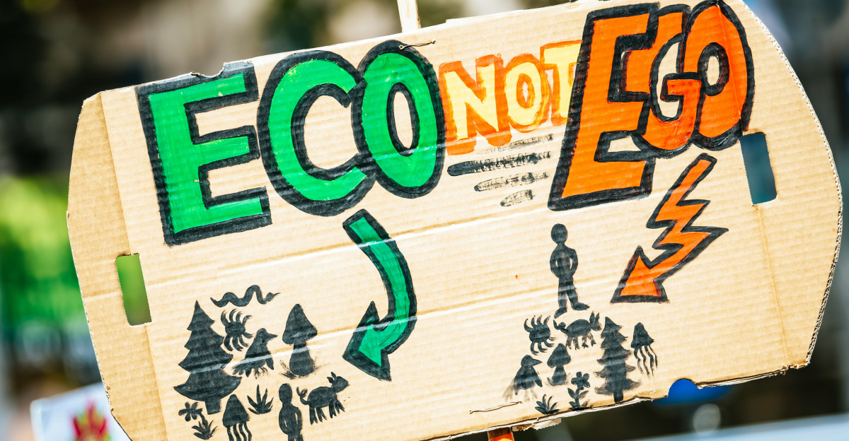 person holding Eco Not Ego signage