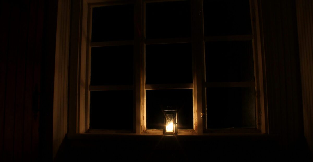 a candle is lit in front of a window