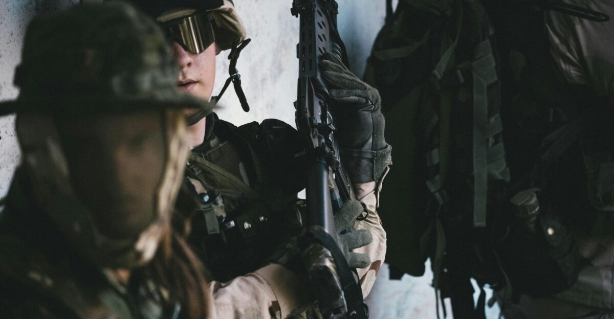 man in black helmet and black helmet holding rifle
