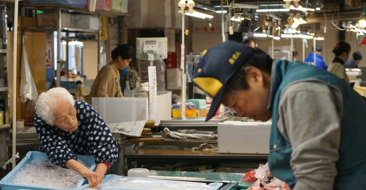 man in blue and white polka dot long sleeve shirt standing near table