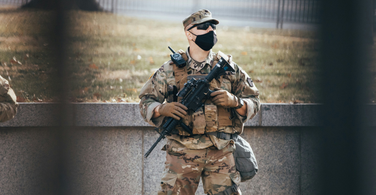 man in brown and black camouflage uniform holding rifle