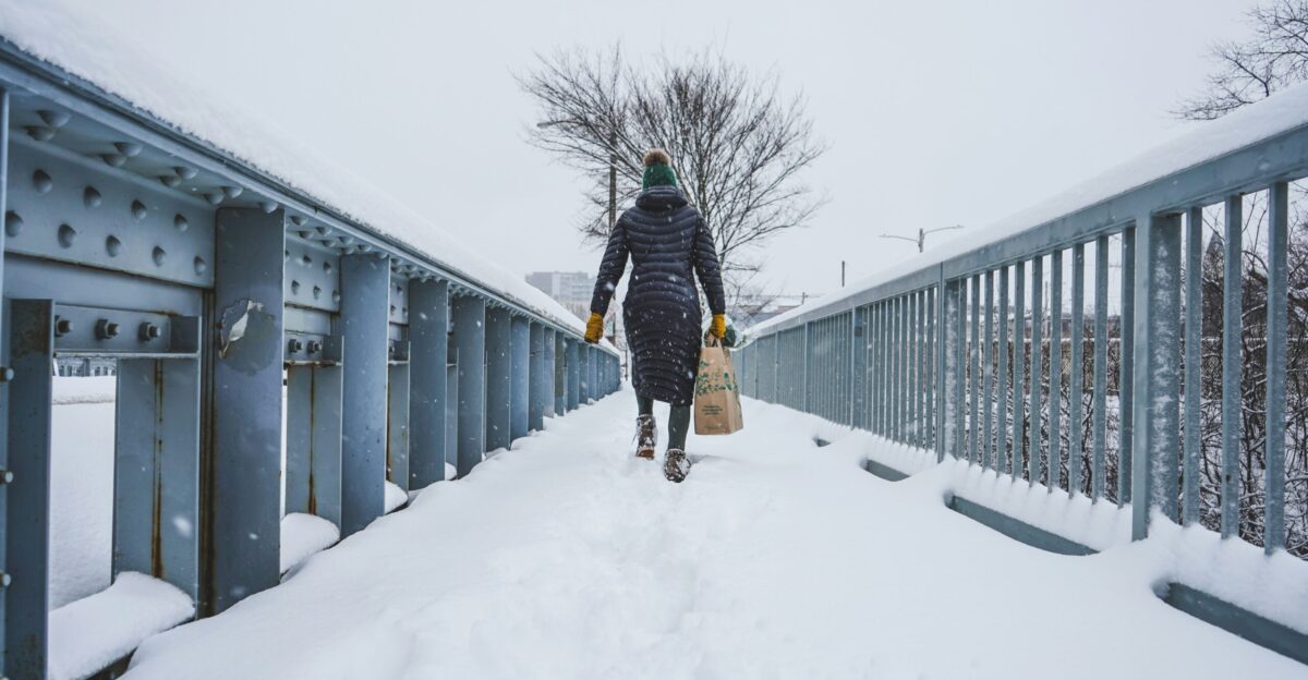 man in black jacket and black pants walking on snow covered pathway
