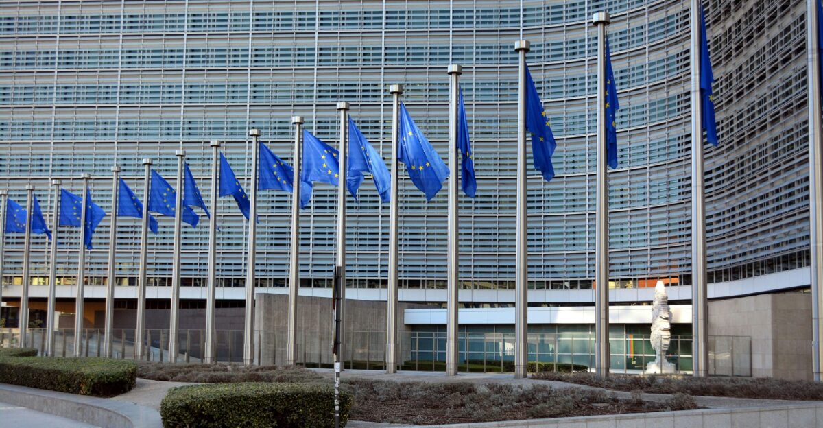 blue flags on poles near building during daytime