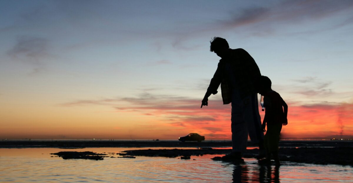silhouette of man and woman kissing on beach during sunset