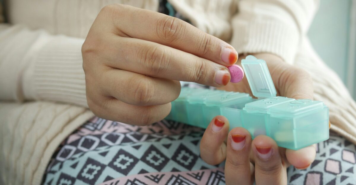 person holding white and green plastic container