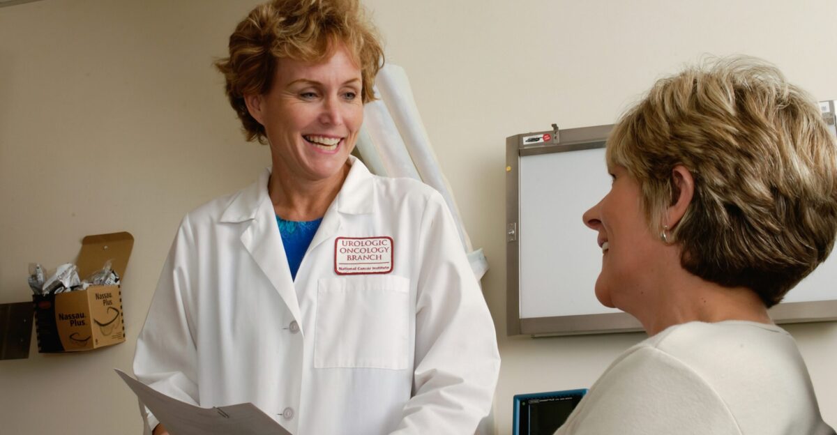 woman in white scrub suit holding gray laptop computer