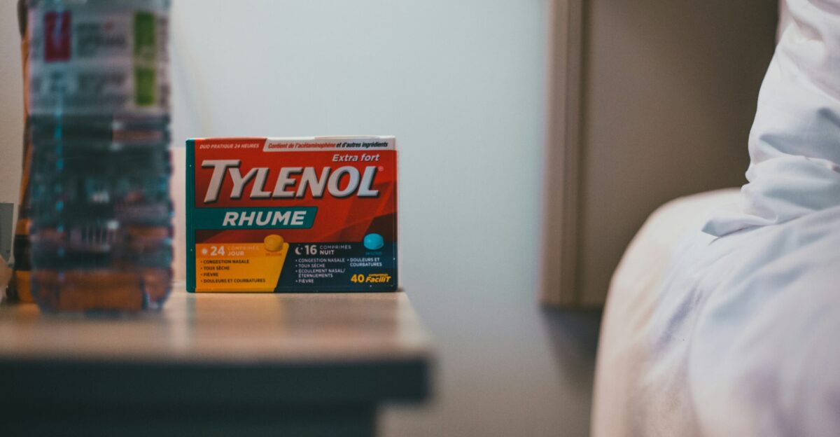 a bottle of tylenol next to a bed