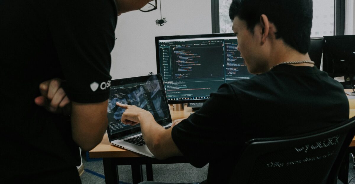 two men working on computers in an office