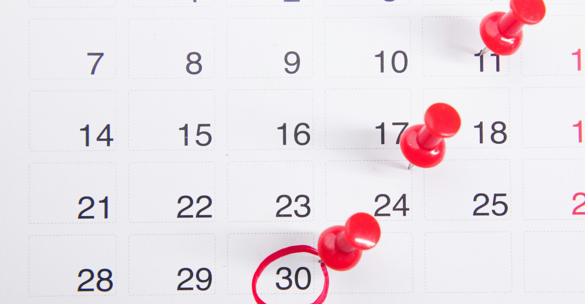 a calendar with red push buttons pinned to it