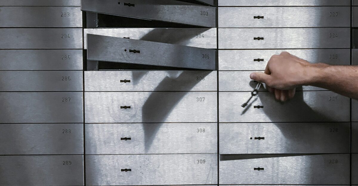 a hand is holding a bunch of keys in front of a metal locker