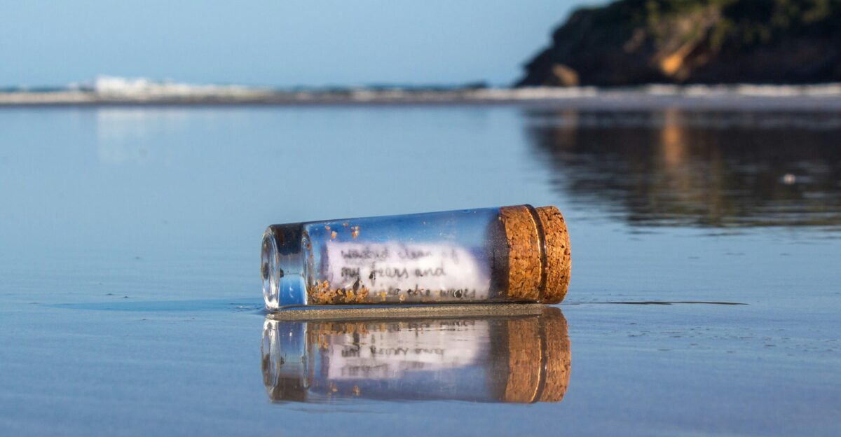 a message in a bottle sitting on the beach