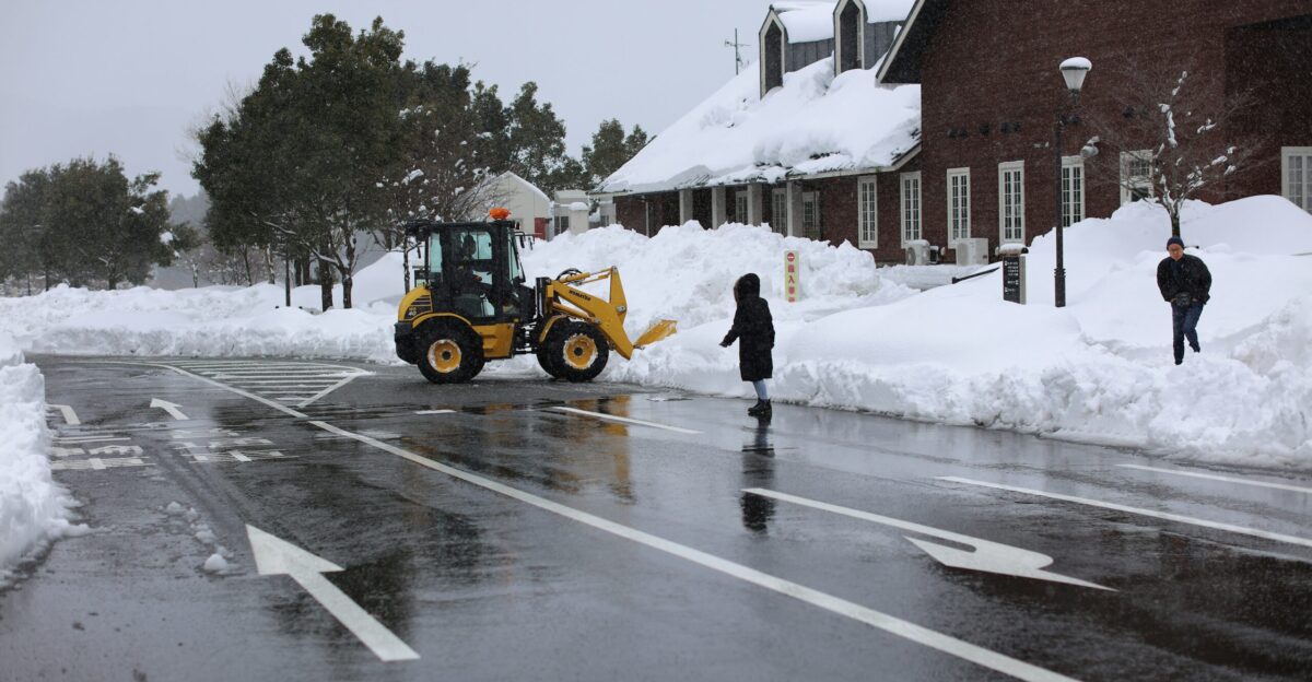 a tractor is parked on the side of the road in the snow