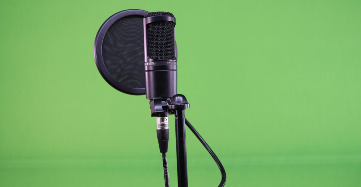 a microphone on a tripod in front of a green background