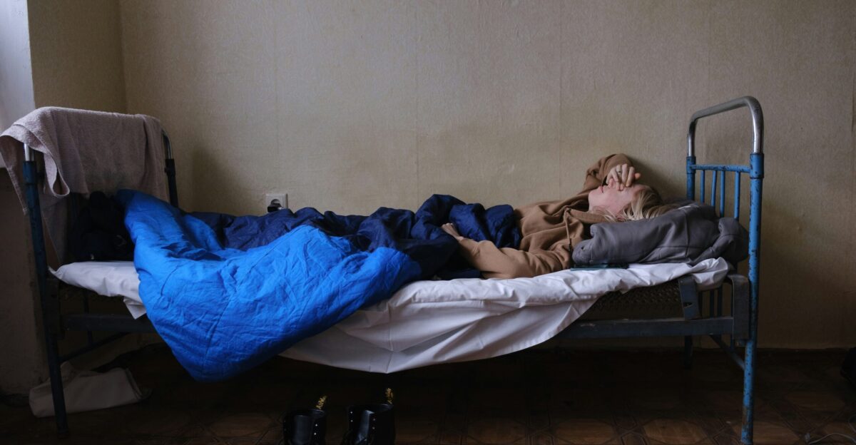 a person laying on a bed with a blue blanket